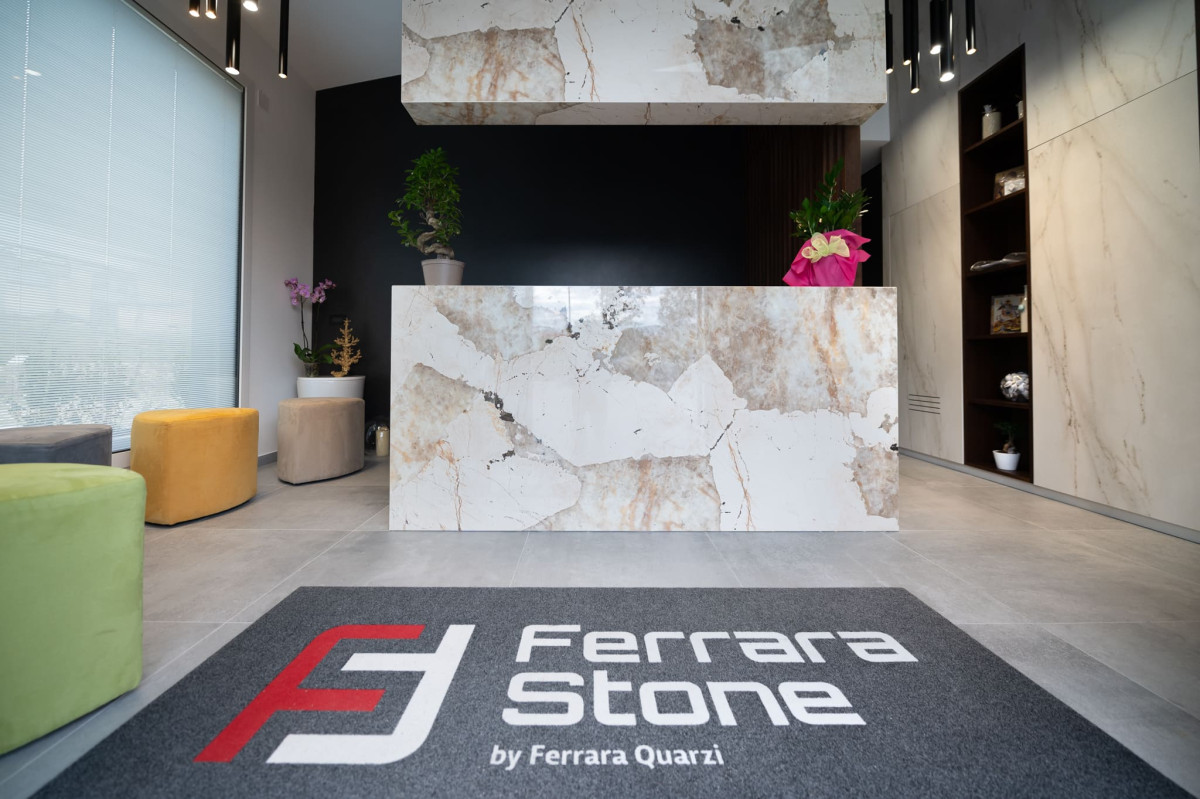Showroom Ferrara Stone — bancone in marmo e logo aziendale